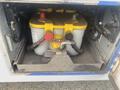 A yellow and gray Optima battery secured in a compartment of a 2017 Chevrolet Express with various wires and connections visible