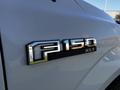 Close-up of the emblem on a 2017 Ford F-150 XLT showing the model name and logo in chrome detailing
