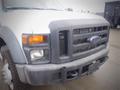 A white 2008 Ford F-550 with a black grille and front bumper featuring one amber turn signal and one headlight