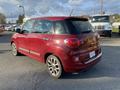 A red 2015 Fiat 500L parked on a paved surface showcasing its compact design and distinctive rear features including round tail lights and a unique shape