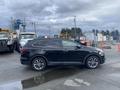 A black 2017 Hyundai Santa Fe is parked on a wet surface with its side profile visible