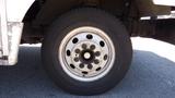 Close-up of a tire and wheel rim from a 2006 Ford Econoline showing multiple lug nuts and a silver-colored rim