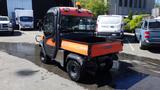 A 2013 Kubota RTV 1100 utility vehicle with an orange and black body featuring a cargo bed and off-road tires parked in a lot