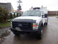 A white 2009 Ford F-450 Super Duty truck with a black front grill and a utility bed in the rear