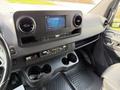 Interior view of a 2019 Mercedes-Benz Sprinter showcasing the dashboard with a display screen and dual cup holders
