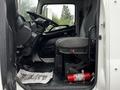 Interior view of a 2020 Hino 338 truck showcasing the driver’s seat steering wheel and dashboard with a fire extinguisher on the floor