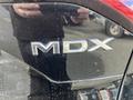 Close-up of the chrome MDX badge on the rear of a black 2023 Acura MDX