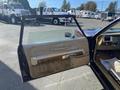 A 1982 Mercury Grand Marquis with its driver's door open displaying a tan interior and wooden trim