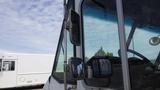 A close-up view of the front driver's side of a 2011 Ford Econoline showing the windshield and side mirrors