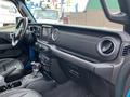 Interior view of a 2020 Jeep Wrangler showcasing the dashboard with control knobs a touchscreen display and leather seating