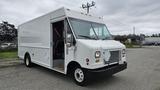 A white 2006 Ford Econoline delivery van with a boxy shape and large front wheels parked at an angle