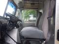 Interior view of a 2007 Morgan Olson Workhorse W42 cab showcasing two gray fabric seats and a steering wheel with dashboard controls visible