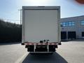 A white 2020 Hino 195 box truck viewed from the rear showcasing its flatbed and taillights with a plain rear door and no visible branding