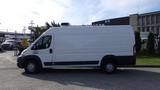 A white 2017 RAM Promaster van parked on a concrete surface with a high roof and sliding side door