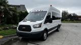 A white 2017 Ford Transit van with a high roof and front grille featuring the Ford logo parked on a paved surface