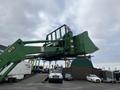 A green 2003 John Deere 790 tractor with a front loader attachment is parked prominently, showcasing its large bucket and robust design