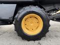 A yellow and black tire from a 1994 John Deere F1145 featuring an aggressive tread pattern and a metal wheel rim