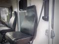 A black vinyl seat from a 2003 Freightliner MT45 Chassis with visible wear and a seatbelt attached