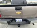 2013 Chevrolet Silverado Hybrid with a silver and black exterior featuring a Chevrolet logo and the word Silverado on the tailgate