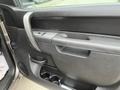 Interior view of a 2013 Chevrolet Silverado Hybrid door with door handle window controls and a cup holder compartment