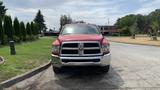 A red 2013 RAM 2500 pickup truck facing the camera showing its chrome grille and front bumper