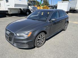 A 2016 Audi A3 in gray with a sleek design and sport wheels parked on a gravel surface