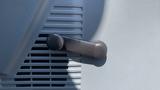 Close-up of a gray door panel lever on a 2011 Ford F-450 SD with ventilation slats visible behind the lever