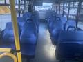 Interior view of a 2017 Chevrolet Express with multiple blue seats arranged in rows and an aisle in the center