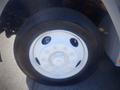 Close-up of a white wheel on a 2006 Freightliner FS65 featuring multiple bolt holes and a smooth tire surface