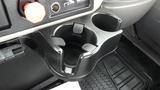 A black cup holder designed to fit in a vehicle console with a circular shape and two grips for stability