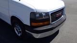 A white 2012 GMC Savana van with a chrome front bumper and black grille featuring the GMC logo