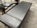 A black padded gym bench with a flat surface designed for exercises and workouts