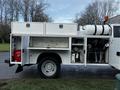 A 2017 Ford F-550 service truck with a white exterior featuring open storage compartments and visible equipment inside