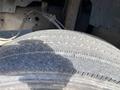 A close-up of a worn tire from a 2003 Ford F-450 SD showing visible tread wear and cracks on the surface