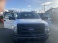 A white 2013 Ford F-150 with open doors showcasing the vehicle's front view and large grille