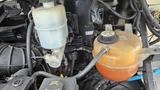 2006 Ford Econoline engine bay with visible coolant reservoir and various engine components