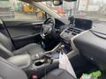 Interior of a 2021 Lexus NX 300 featuring black leather seats a modern dashboard and a center console with controls and a cup holder