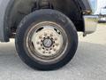 Close-up of a rusted wheel of a 2010 Ford F-550 showing the tire and rim with visible wear and dirt