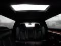 Interior of a 2008 Cadillac Limousine featuring black leather seats and a sunroof above, with rain droplets on the glass