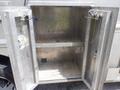 An open metallic storage compartment with two doors revealing empty shelves inside, typically found on a Morgan Olson Workhorse W42 vehicle