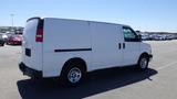 A white 2012 GMC Savana van parked in a lot with a sliding side door and round wheels