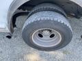 Close-up of the rear tire and rim of a 2008 Ford Econoline showing tread wear and metallic wheel details