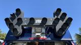 A 2013 Ford Econoline with a large black light fixture mounted on the roof featuring multiple circular openings and a central control panel