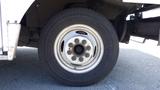 Close-up of a wheel on a 2011 Ford Econoline showing the white rim with multiple lug nuts and a black tire