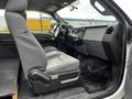 Interior of a 2014 Ford F-250 SD with gray seats and a control panel featuring various knobs and buttons