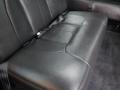 A plush black leather bench seat in a 2008 Cadillac Limousine with a seatbelt and subtle stitching details