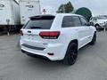 A white 2018 Jeep Grand Cherokee with a sporty design featuring a rear spoiler and black accents