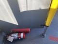 A red fire extinguisher placed on the floor next to a vertical support pole inside a vehicle