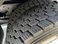Close-up of a heavily treaded tire from a 2016 Isuzu NPR showcasing deep grooves and rugged rubber designed for traction on various surfaces