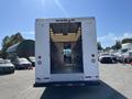 A white 2007 Ford Econoline van with an open rear door revealing a spacious cargo area inside